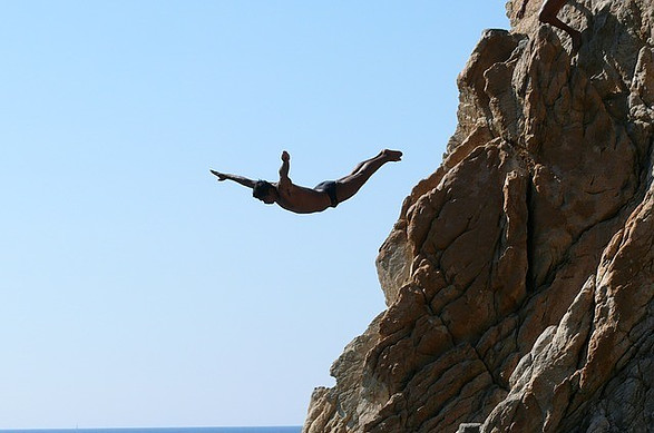 Man diving into the water with his arms extended.