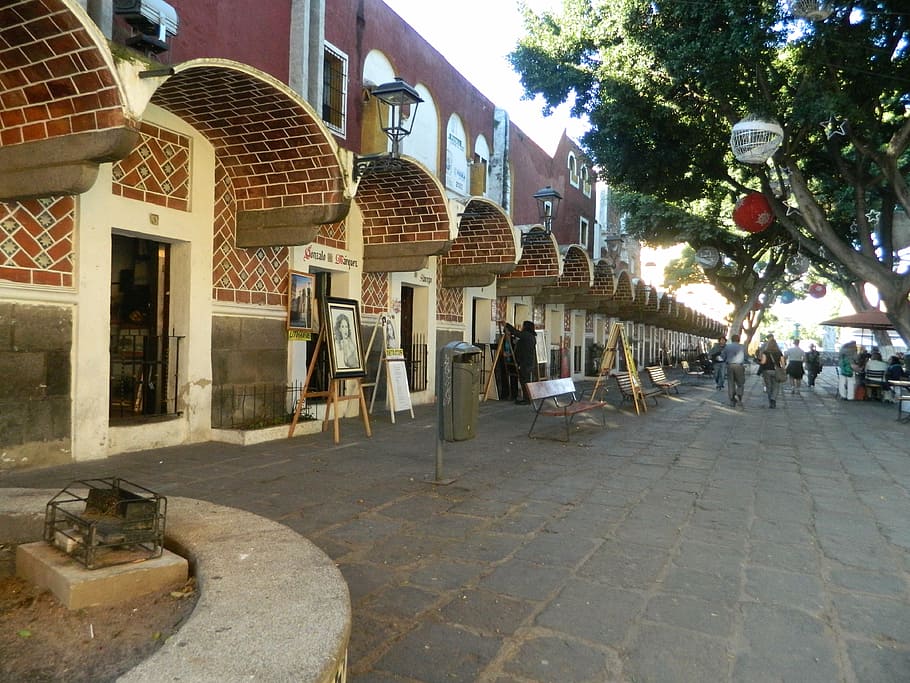 Corridor with brick buildings lined up with artists showing their work.