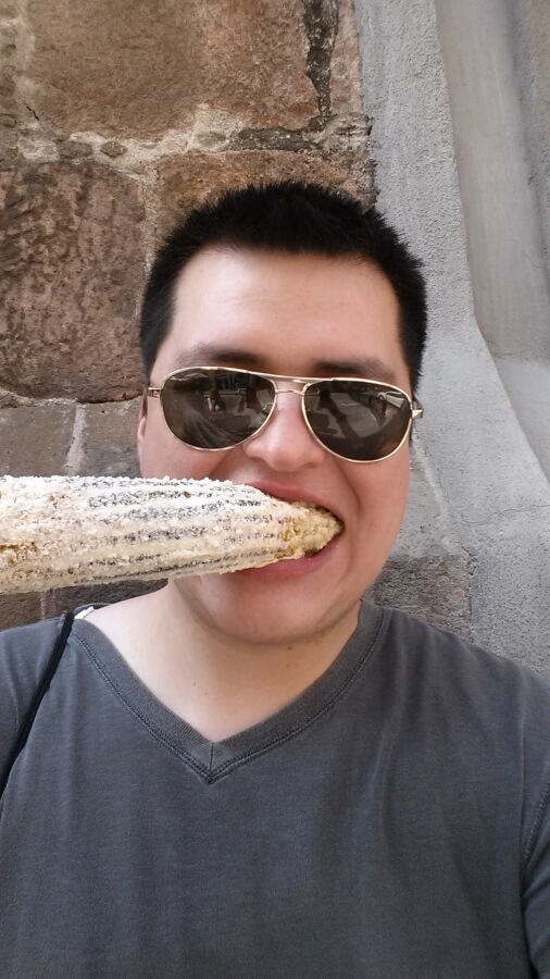 A young man eating corn on the cob.