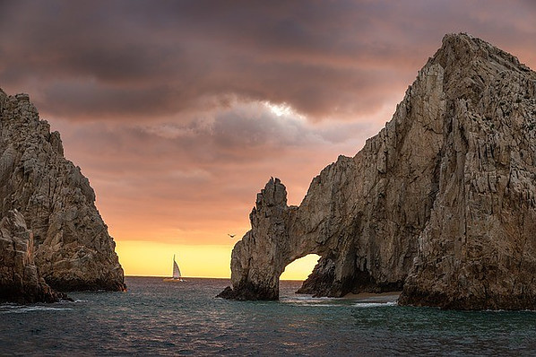 Mountain in the middle of the sea with an arch.