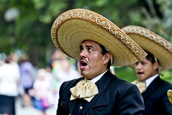 Mexican man singing dressed in mariachi attire.