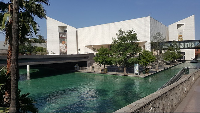 Artificial canal with a square, white building in the back.