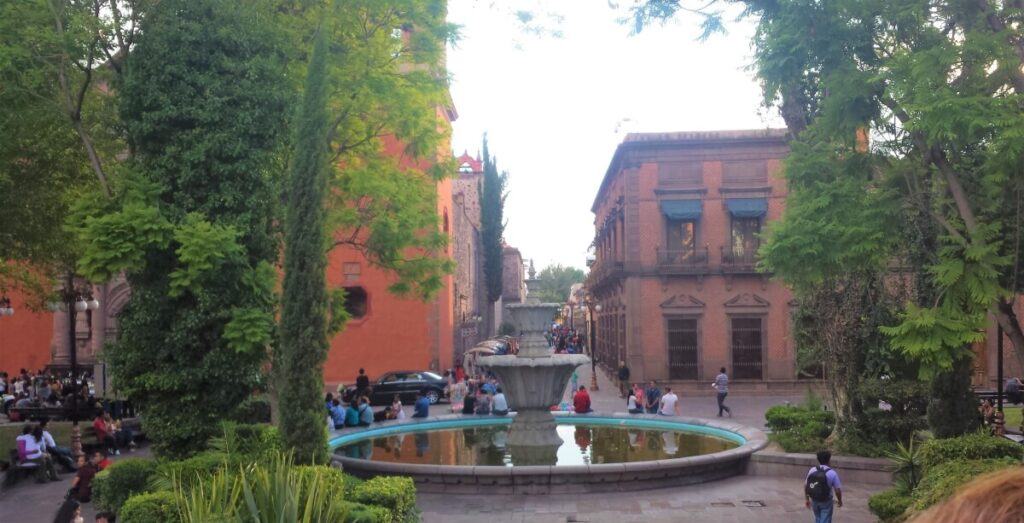 Fountain in the middle of a colorful plaza.