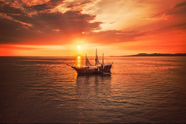 Boat in the middle of the sea with the sunset as backdrop.