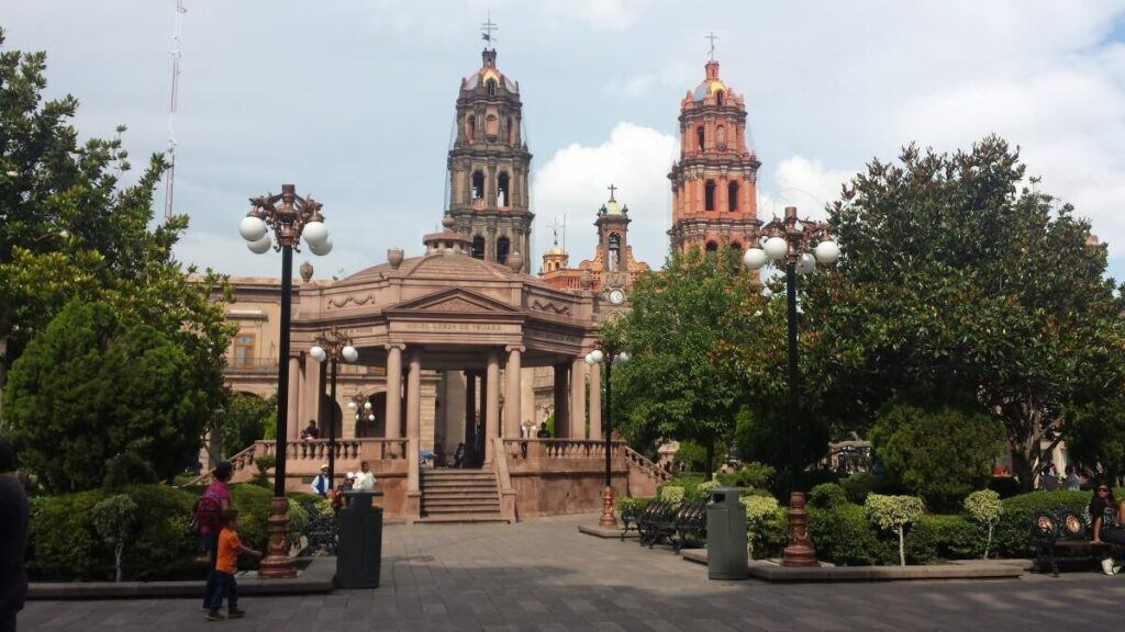 Pink stone gazebo and church at a city center.