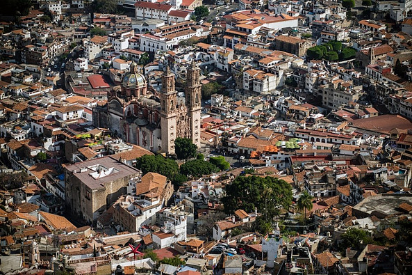 A typical colonial city in Mexico with white houses, red tile roofs and the church in the middle.