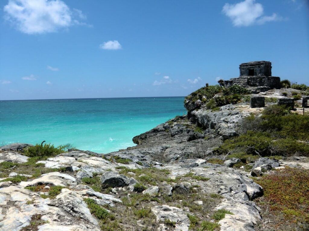 Turquoise water right next to a cliff.