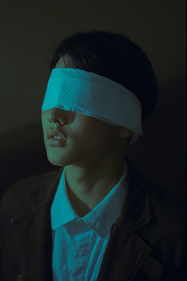 Man with a white blindfold.