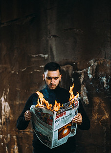 Man reading a burning newspaper.