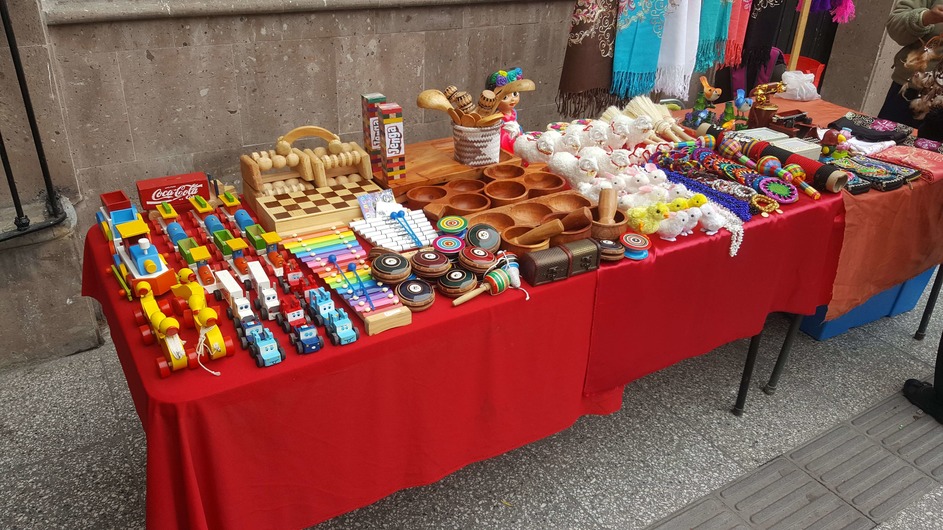 Several Mexican handicrafts on a red table.