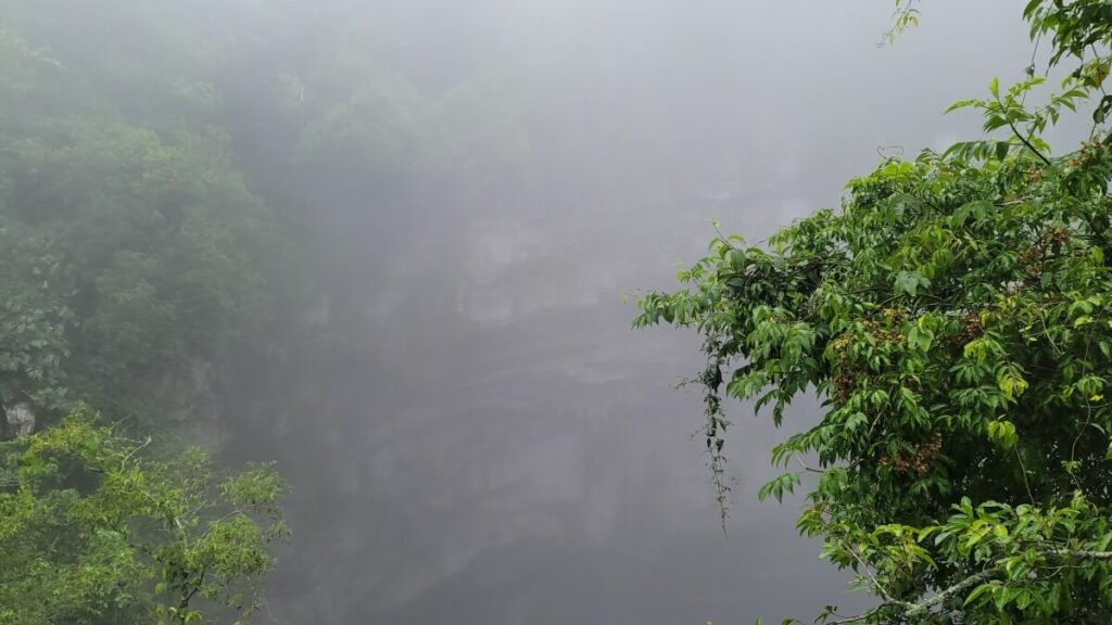 An open air cave with fog inside.