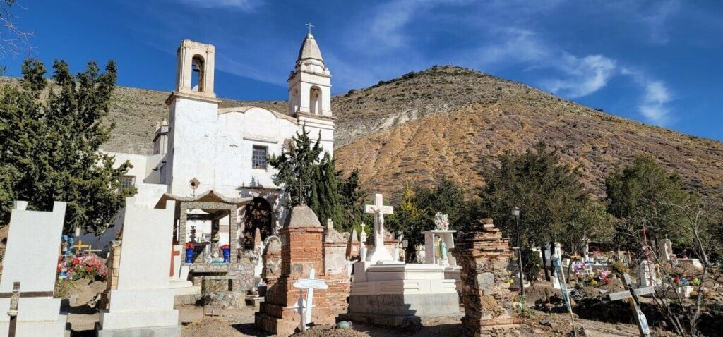 A cemetery and a white church in the back.