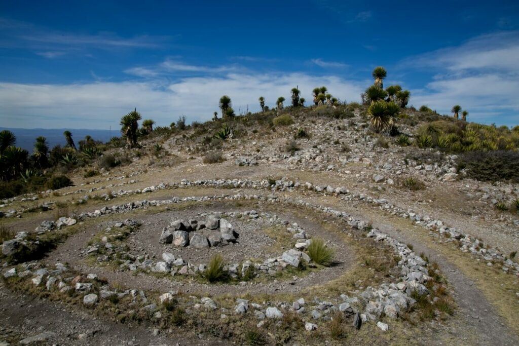 Several rocks arranged like a spiral on top of a hill.