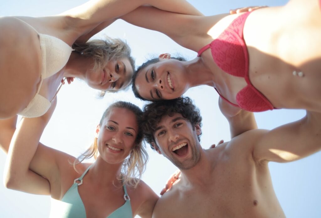 Group of three girls and one guy hugging each other and forming a circle.