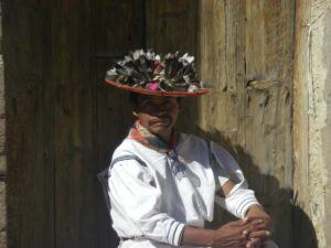 Man seated and wearing traditional Huichol clothing.
