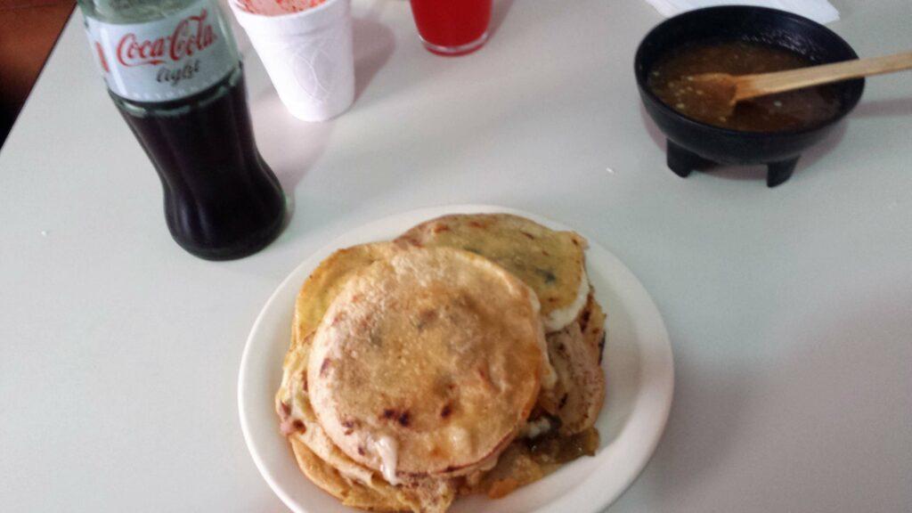 A plate of Mexican gorditas and a diet coke.