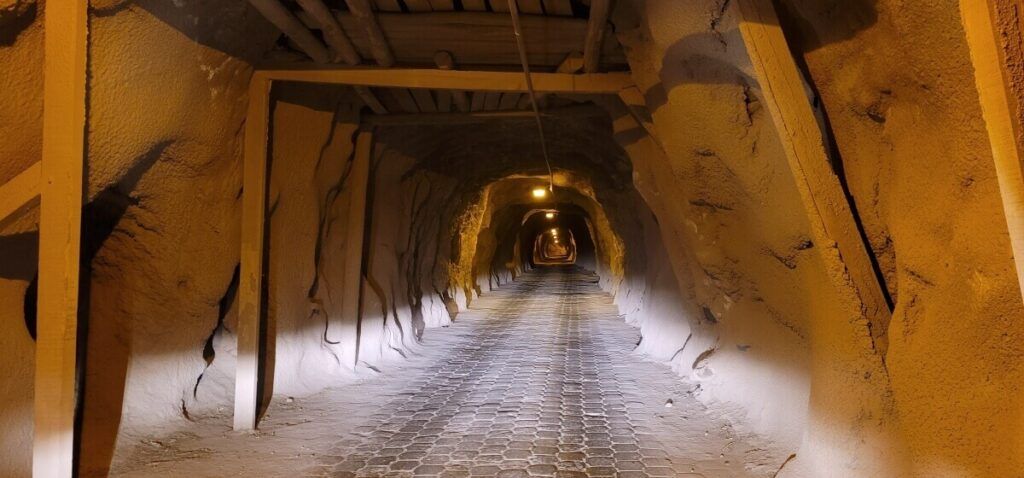 Interior of a dark tunnel supported by wooden beams.