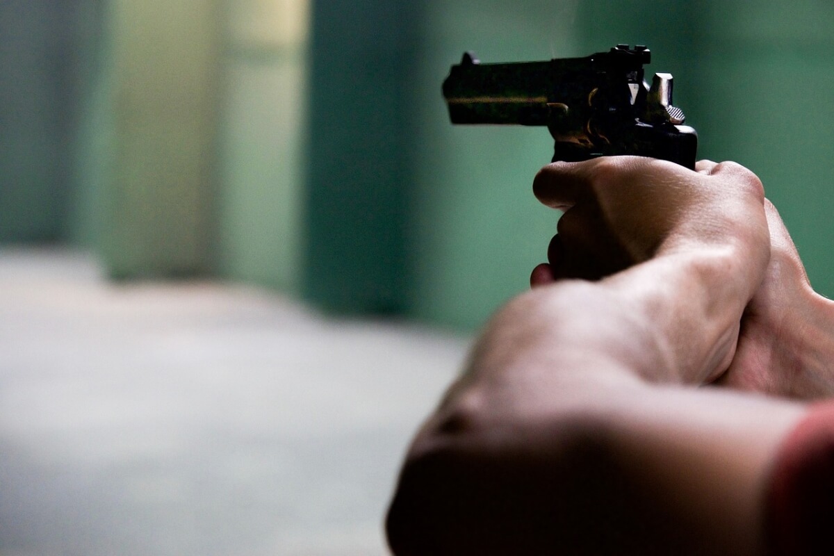 Black man holding a gun in his hands.