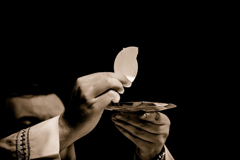 Priest holding a wafer in his hand.