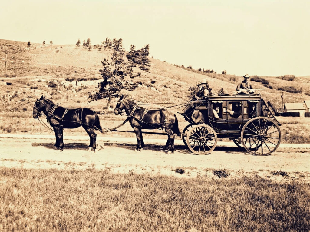 Men escorting a stagecoach.