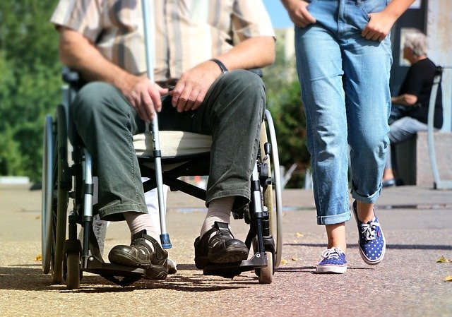 Elder using a wheelchair and a cane.