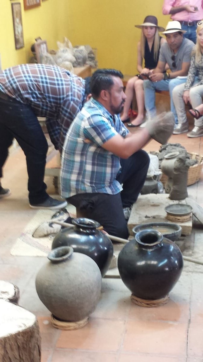 An artisan showing how to make barro negro pottery.