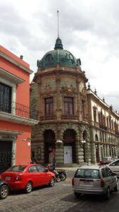 Theater on a corner with a green dome.