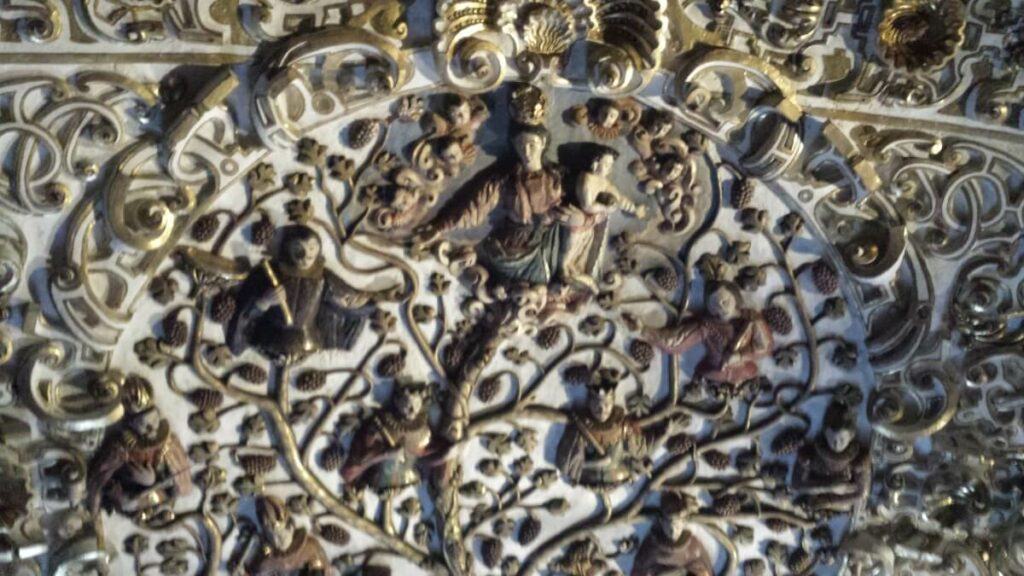 Several saints carved in the ceiling of a church.