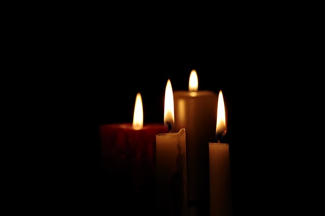 Four candles burning in the darkness.