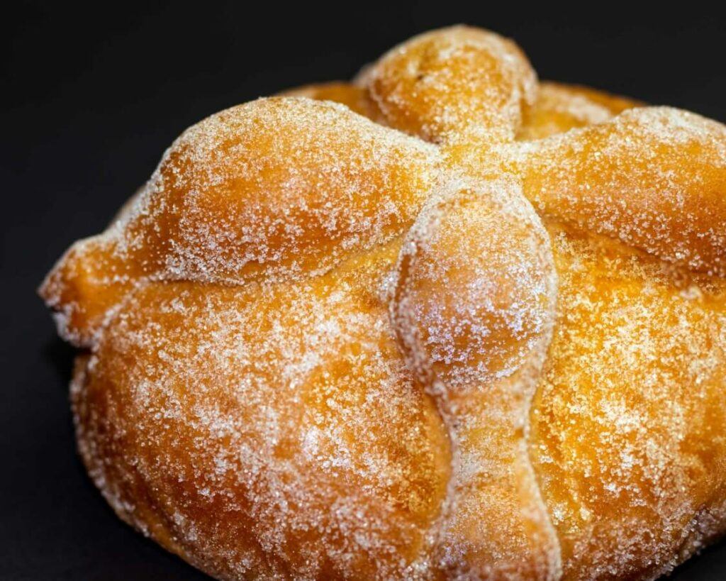 Round bread with a cross on top and sprinkled with sugar.