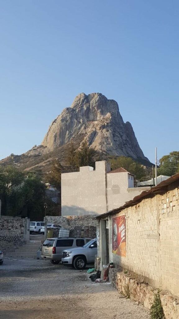 A small town with a giant monolith in the background.