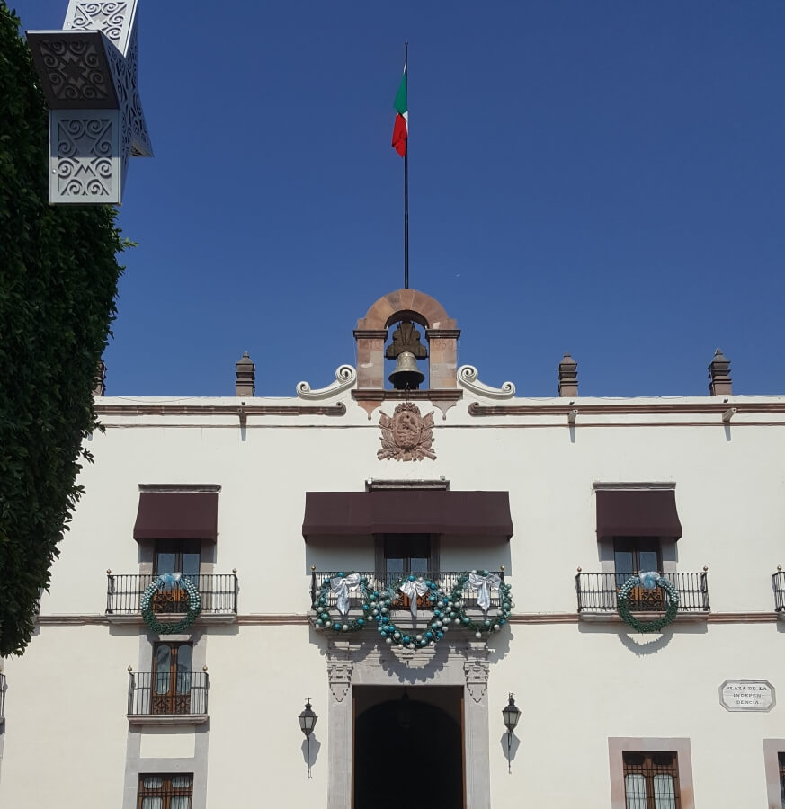 White city hall with the Mexican flag on top.