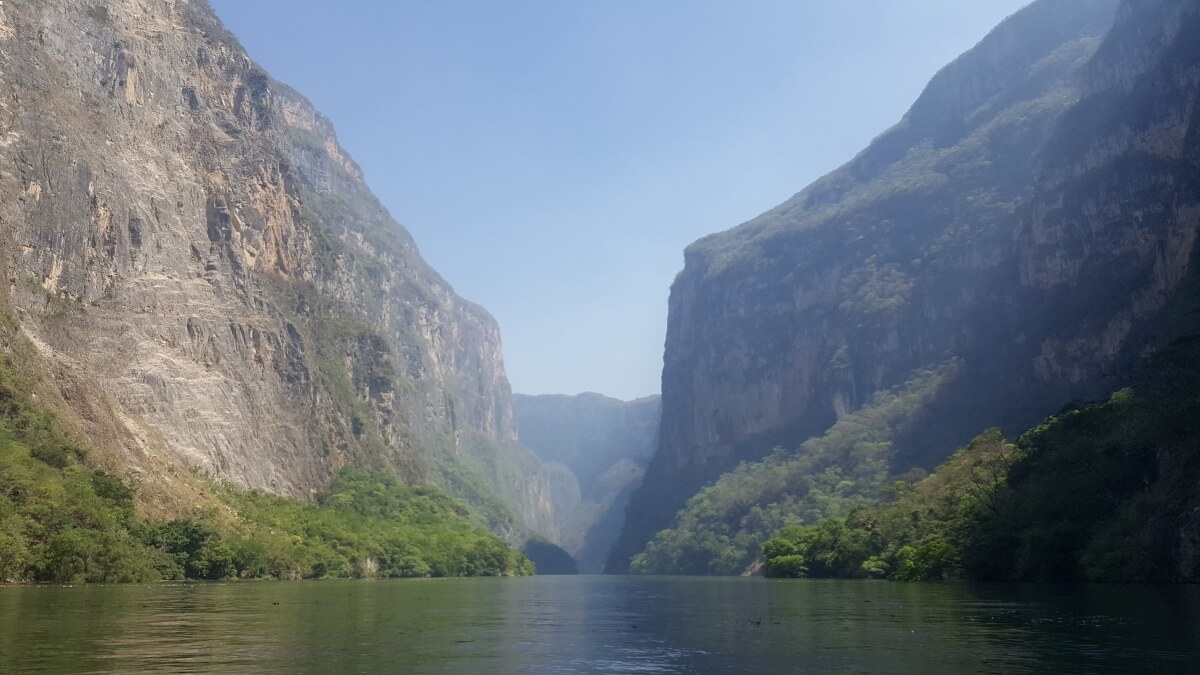 View of three mountains along a river.