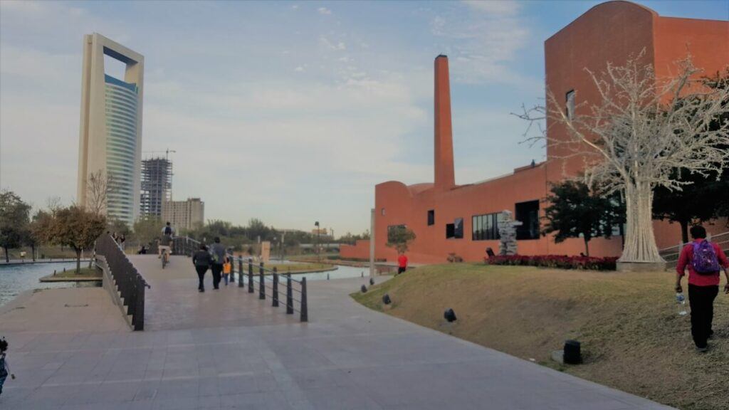 Several people walking or riding bikes at an urban park.