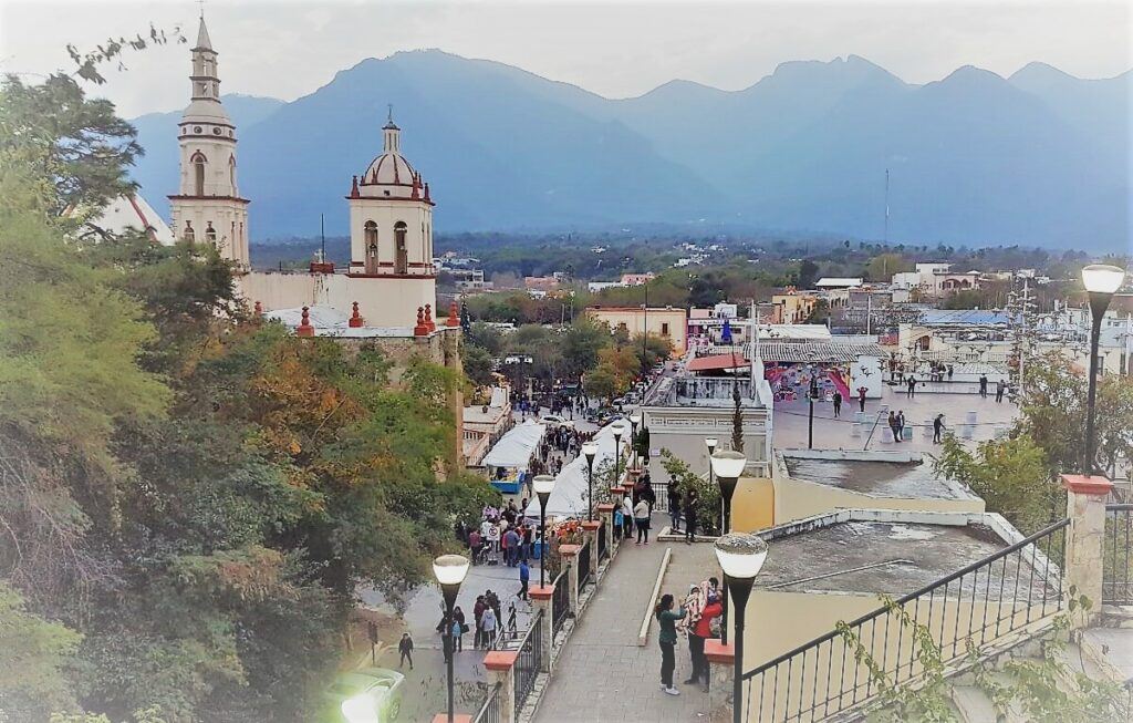 A small town with mountains seen from an observation deck.