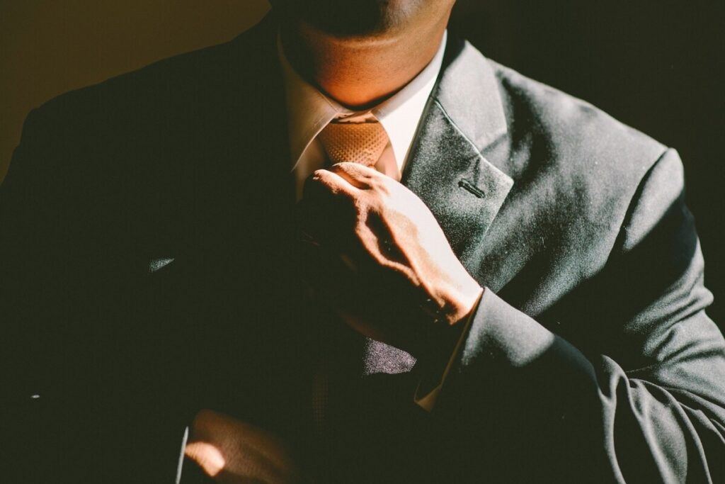 A man adjusting his tie.