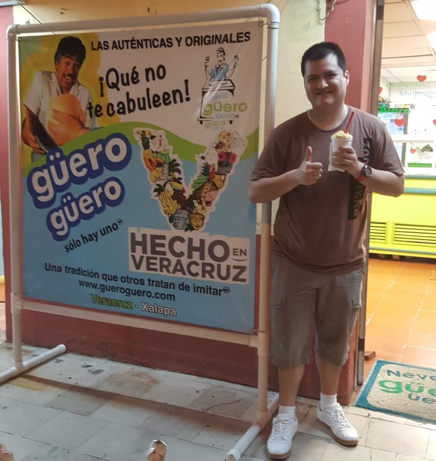 A young man in brown holding a sorbet.