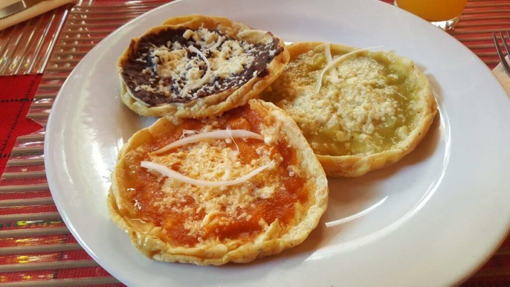 Three picaditas with sauce and cheese.