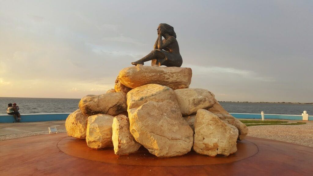 Statue of a woman looking at the sea.