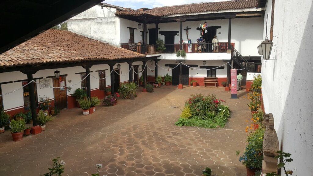 A courtyard with white and red buildings around it.