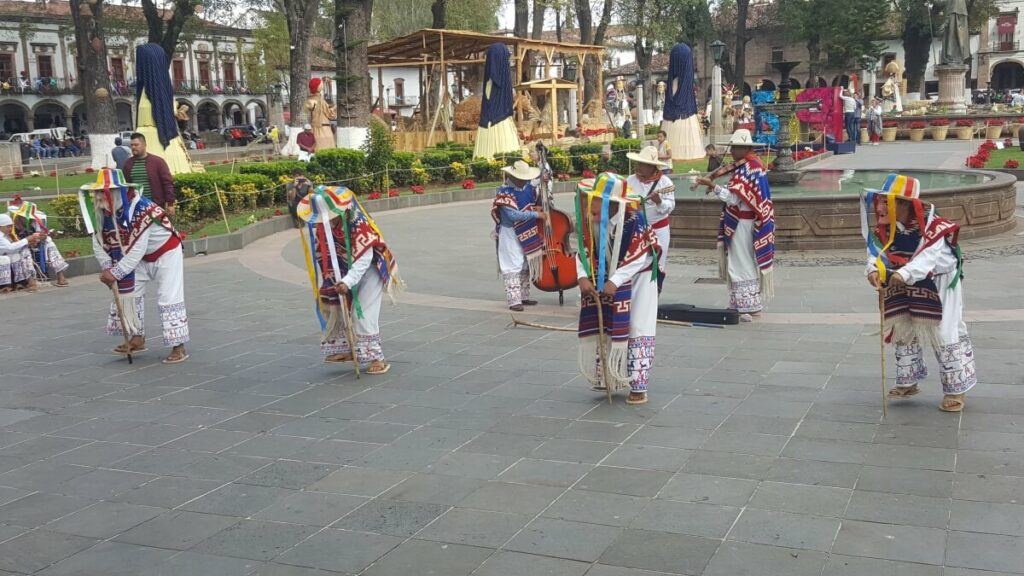 Young men dressed with old men's masks and dancing.