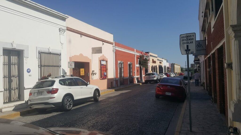 Several cars parked in the downtown area of a city.