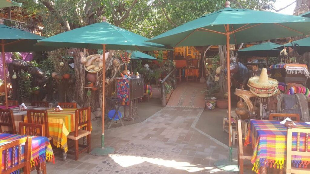 A restaurant patio with colorful tables and umbrellas.