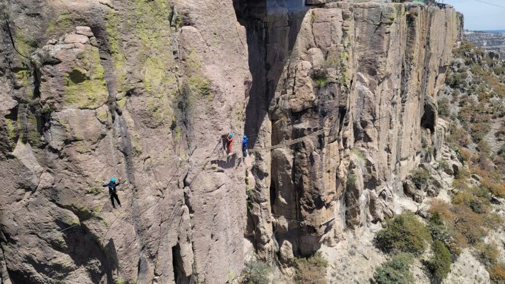 People walking along the edge of a mountain.